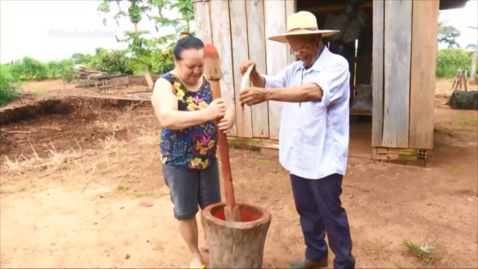 Casal prepara urucum no pilão em Ariquemes — Foto: Rede Amazônica/Reprodução