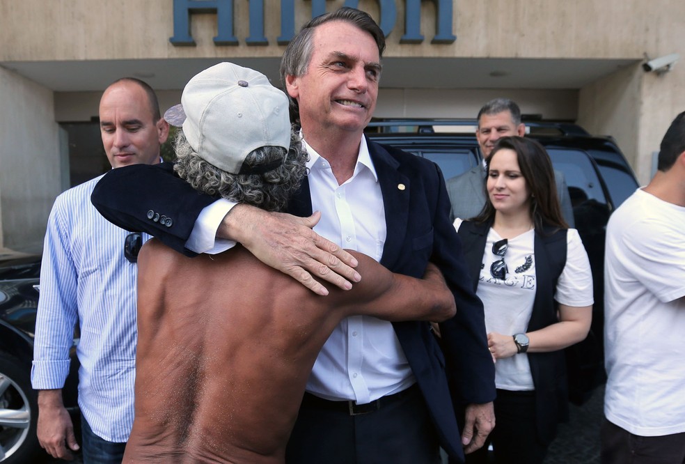 Bolsonaro abraça um morador de rua ao chegar ao Hotel Hilton, em Copacabana, para participar de um almoço com empresários do setor de seguros (Foto: Wilton Junior, Estadão Conteúdo)