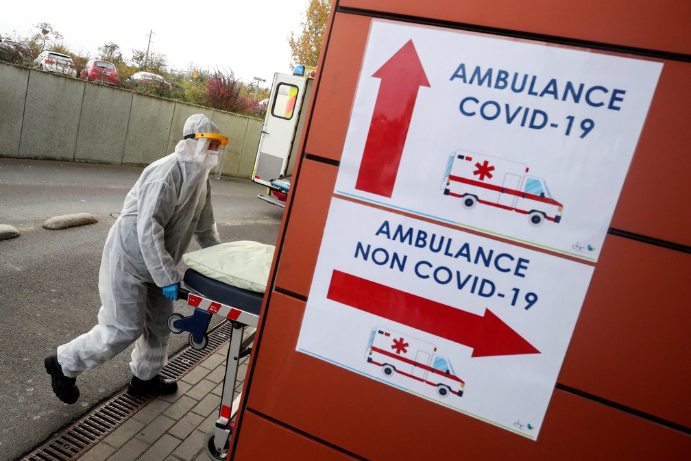 Profissional da saúde com roupa de proteção (EPI) empurra uma maca do lado de fora de hospital em Auvelais, na Bélgica, durante a pandemia do novo coronavírus (Covid-19) — Foto: Yves Herman/Reuters