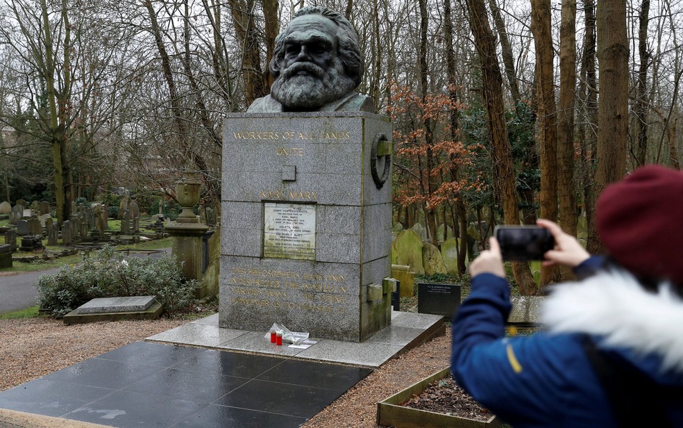 Mulher fotografa túmulo do filósofo alemão Karl Marx, no cemitério Highgate, em Londres — Foto: Reuters/Peter Nicholls
