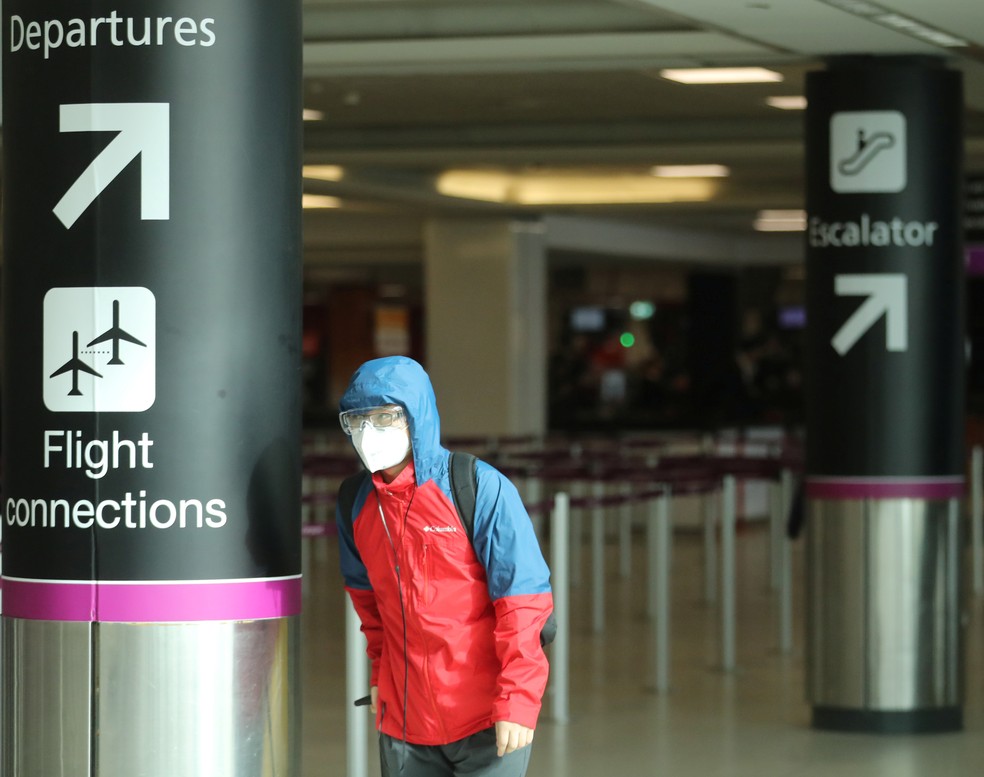 Em 2020, passageiro usa máscara e óculos protetores contra a Covid em aeroporto de Edimburgo, na Escócia. — Foto: Russell Cheyne/Reuters