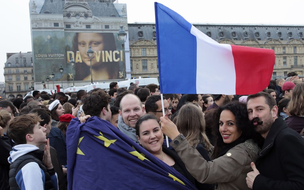 Bandeiras da França e da União Europeia se encontram durante comemoração da vitória de Macron (Foto: Buhran Ozbilici/AP Photo)
