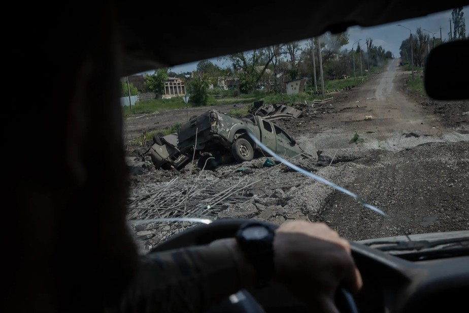 Soldados ucranianos dirigem por veículos destruídos nos arredores de Bakhmut