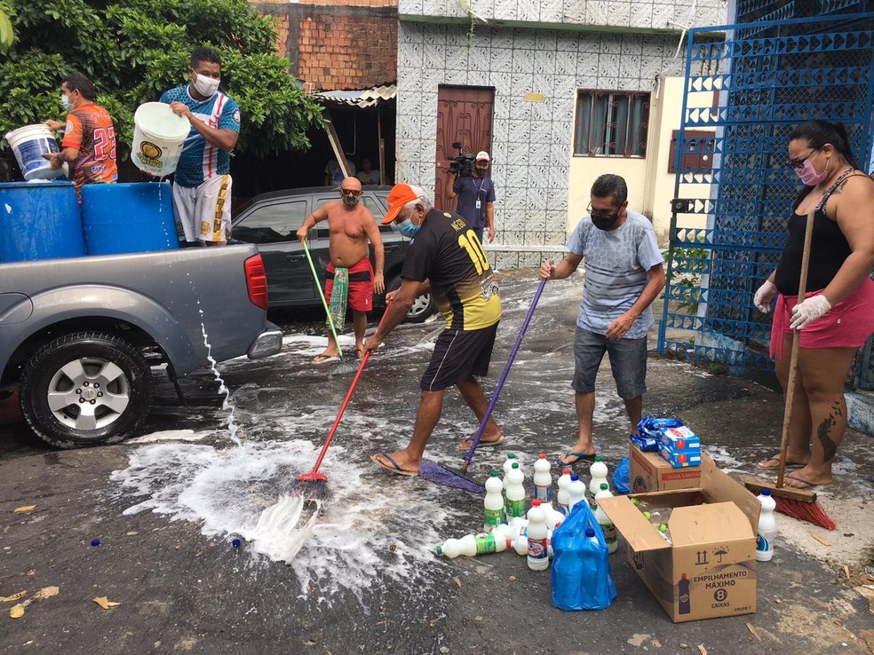 Moradores lavam ruas de Manaus para tentar conter o vírus — Foto: Amanda Bulcão/Rede Amazônica