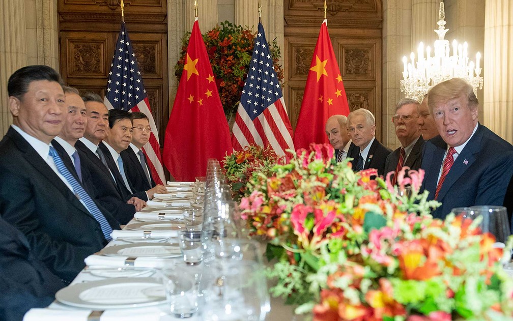 O presidente dos EUA, Donald Trump (à direita na mesa), e o presidente da China, Xi Jinping, juntamente com as delegações dos dois países, durante jantar após a cúpula do G20 em Buenos Aires — Foto: Saul Loeb / AFP Photo