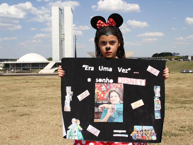Maria Rita vestida de MInnie e com cartaz de protesto contra a alta do dólar, que fez com que pai adiassem viagem aos EUA (Foto: Vianey Bentes/TV Globo)
