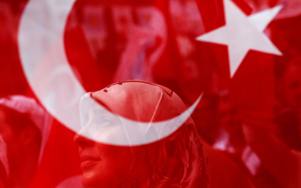 Mulher é vista através de bandeira turca em evento eleitoral em Istambul (Foto: Alkis Konstantinidis / Reuters)