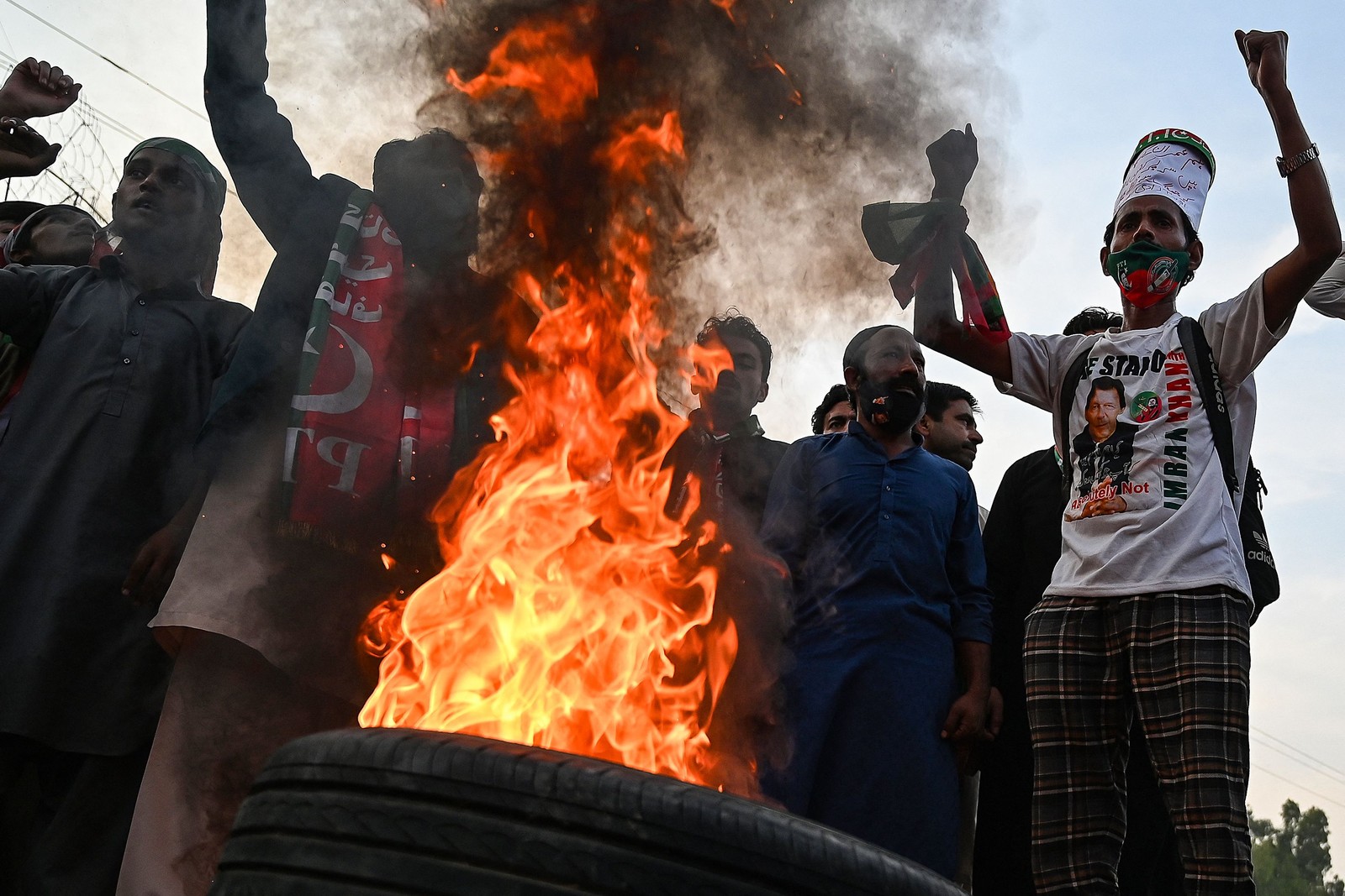 Apoiadores do ex-primeiro-ministro paquistanês Imran Khan protestam enquanto bloqueiam uma estrada um dia após a tentativa de assassinato em Khan, em Wazirabad. — Foto: Aamir QURESHI / AFP