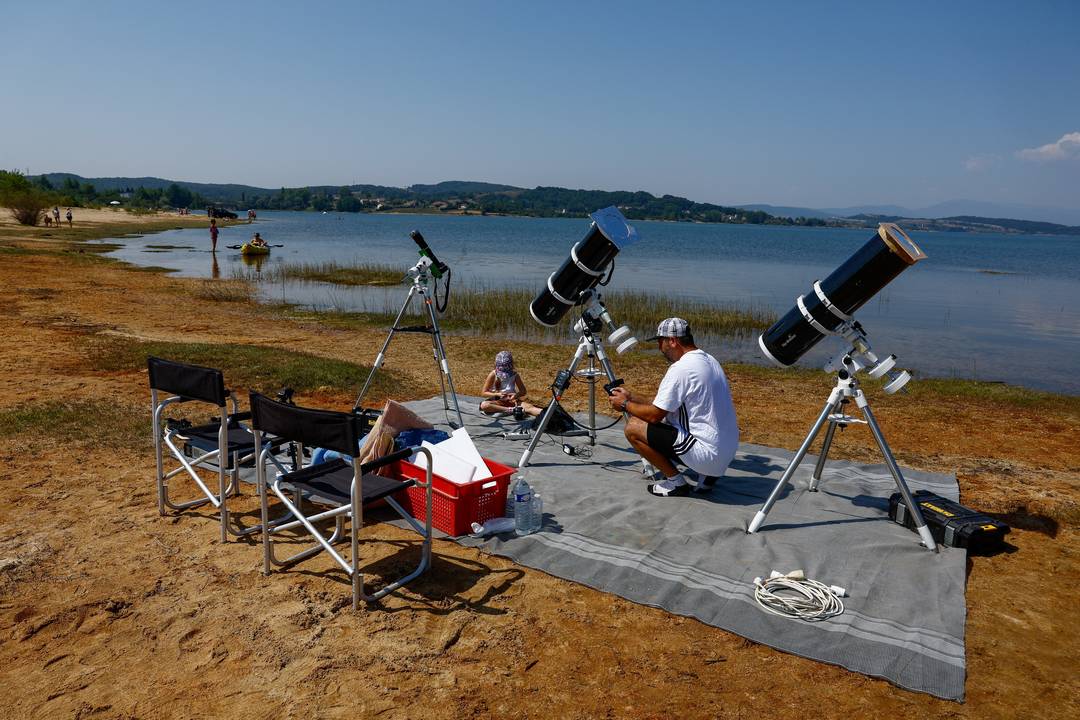 O francês Leyssalle Anthony, de 39 anos, prepara um telescópio na praia para observar o eclipse solar total em Arija, na Espanha, nesta quarta-feira (12).