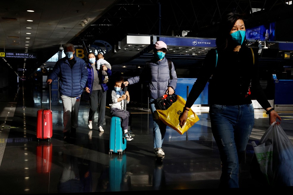 Viajantes caminham por dentro do aeroporto de Pequim, na China — Foto: Tingshu Wang/REUTERS