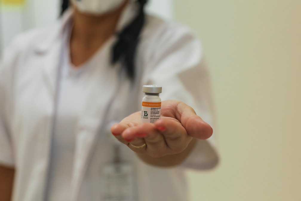 Profissional da saúde com frasco da vacina CoronaVac. — Foto: Leonardo Rosito/PMPA