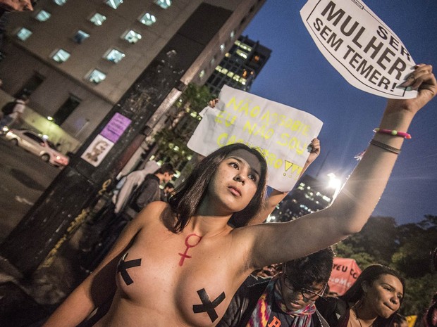Mulher de topless com os mamilos cobertos ergue cartaz com a frase &#39;Ser mulher sem temer&#39; no protesto &#39;Por Todas Elas&#39;, contra a cultura do estupro e a violência praticada contra as mulheres, na Avenida Paulista, em São Paulo (Foto: Cris Faga/Fox Press Photo/Estadão Conteúdo)