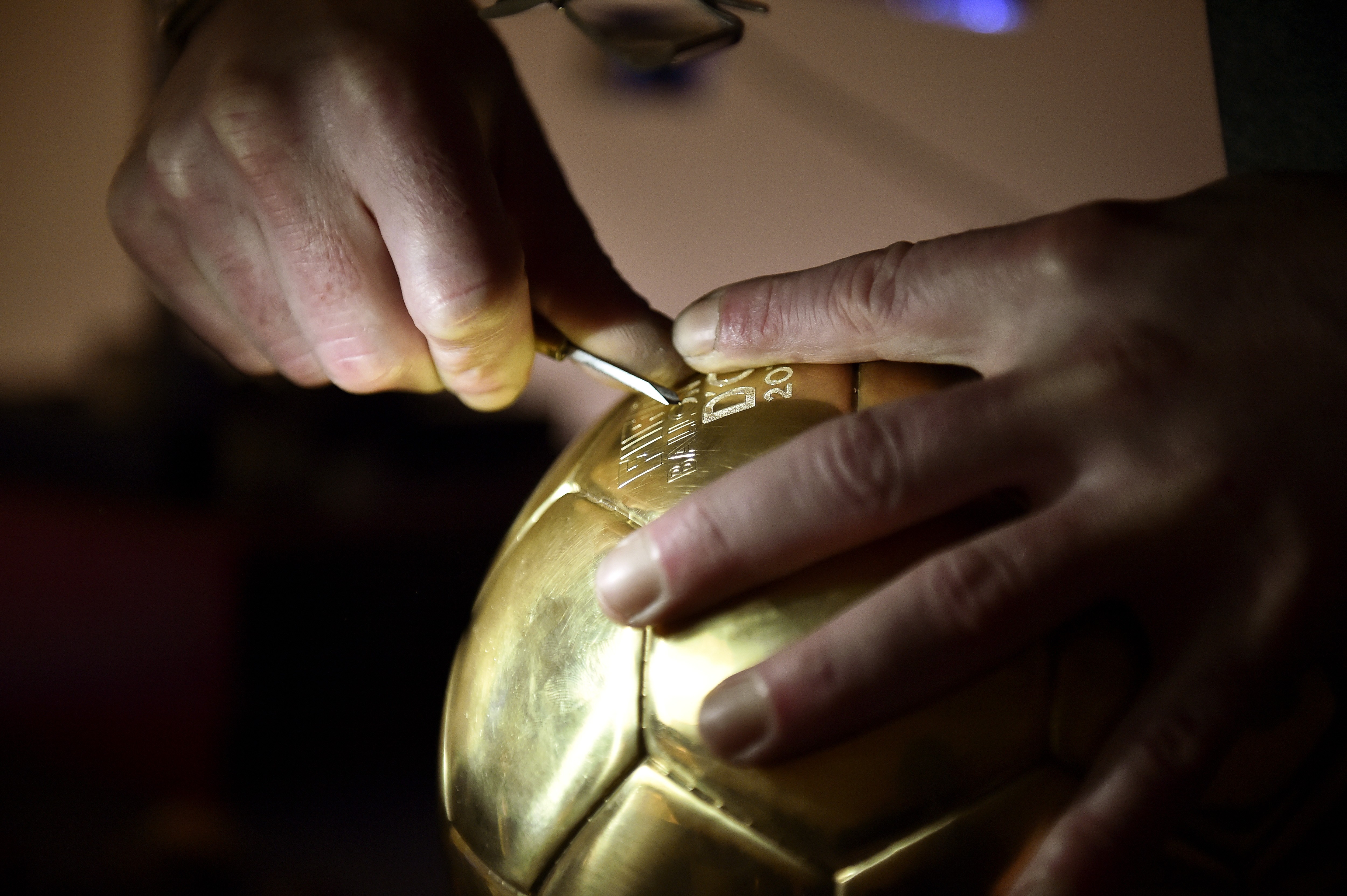 An engraver works on the "Ballon D'or" in Paris on December 2 2014, at the French jewelry house Mellerio. Neuer, Messi, Ronaldo were chosen as top three candidates for FIFA Ballon d'Or with the winner due to be announced on January 12, 2014.  AFP PHOTO /  (Foto: AFP)