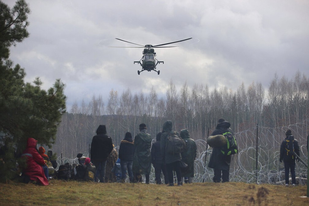 Helicóptero militar da Polônia vigia grupo de migrantes que tenta entrar no país por meio da fronteira com Belarus nesta segunda (8) — Foto: Leonid Shcheglov/BelTA via AP