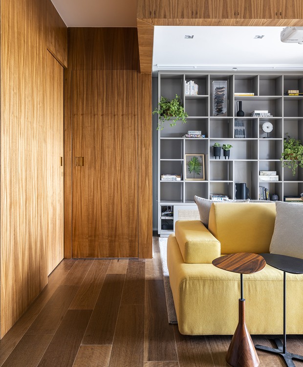 Living | Painéis e portas de madeira ajudam a organizar a distribuição de espaços no apartamento integrado (Foto: Renato Navarro/Divulgação)