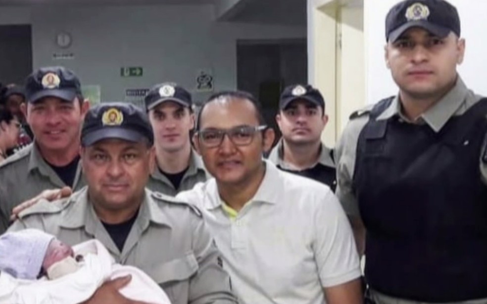 Policiais militares posam com a bebê que nasceu dentro de carro, em Aparecida de Goiânia (Foto: Reprodução/TV Anhanguera)