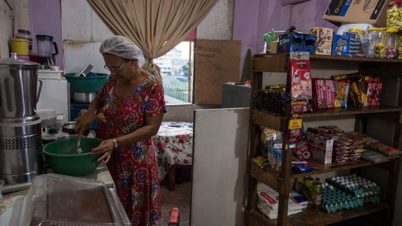 Moradora de ocupação em São Paulo cozinha; em todas as faixas de renda, mulheres cuidam muito mais da casa do que os homens (Foto: NELSON ALMEIDA/AFP VIA GETTY IMAGES)