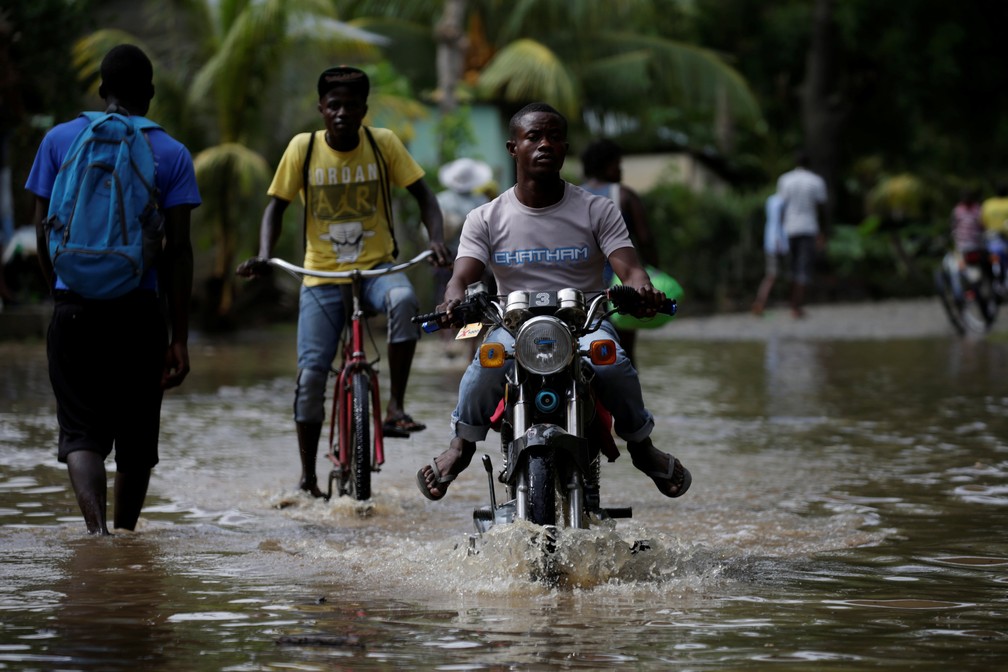 Homem anda de motocicleta no meio de inundação após a passagem do furacão Irma pelo Haiti. (Foto: Andres Martinez Casares/Reuters)