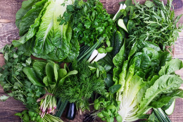 Fresh organic homegrown herbs and leaf vegetables background. Arugula, romaine lettuce,dill, parsley,  cilantro, green onion,basil, cucumber and spinach bunches on wooden background viewed from above (Foto: Getty Images)