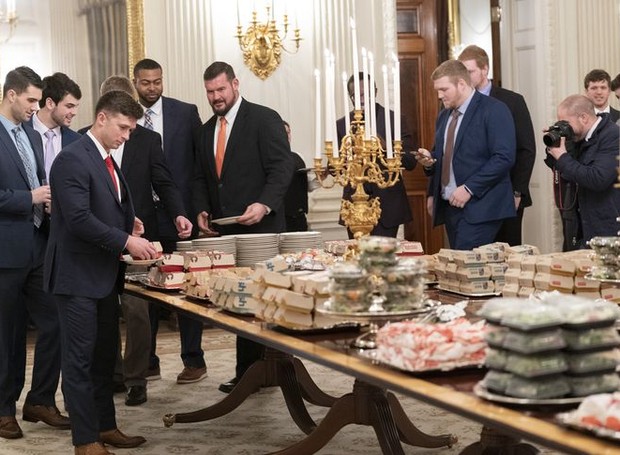 O presidente Donald Trump ofereceu um banquete de fast food aos jogares da liga universitária de futebol americano (Foto: Getty Images/ Delish /Reprodução)