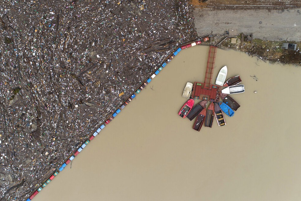 Barcos ao lado do 'lixão flutuante', no rio Drina perto de Visegrad, Bósnia, sexta-feira, 20 de janeiro de 2023. — Foto: AP Photo/Armin Durgut