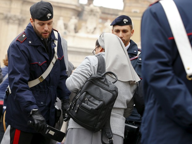 Policiais italianos inspecionam os pertences de uma freira antes da audiência geral do Papa Francisco, na Praça São Pedro, no Vaticano, na quarta (18)  (Foto: Reuters/Tony Gentile)