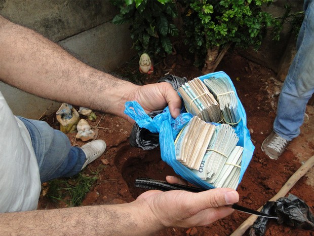 Cerca de R$ 46 mil estavam enterrados em quintal. (Foto: Polícia Civil)