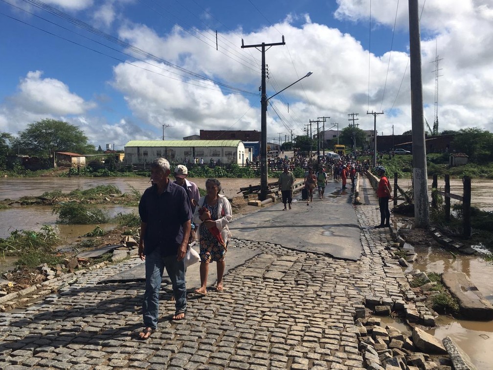 Moradores de Coronel João Sá passando por ponte na manhã de sábado (13), com monitoramento do Corpo de Bombeiros — Foto: Alan Tiago/G1