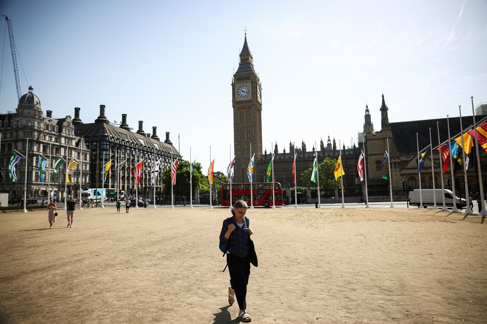 Uma mulher anda de frente ? sede do Parlamento da Inglaterra durante onda de calor ? Foto: Henry Nicholls/REUTERS