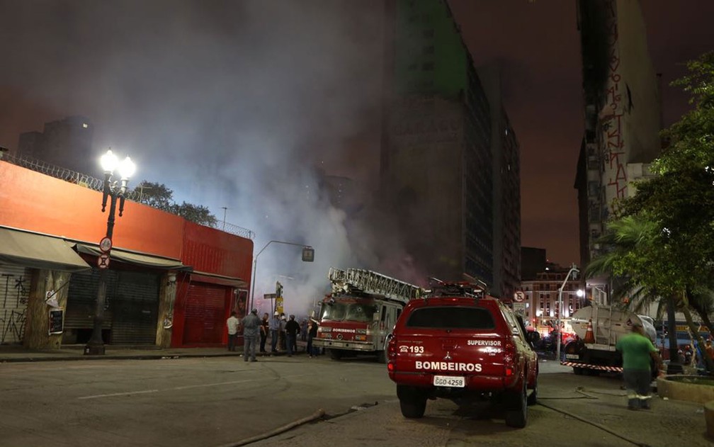 Bombeiros combatem focos de incÃªndio nos escombros do prÃ©dio que caiu (Foto: Celso Tavares/G1)