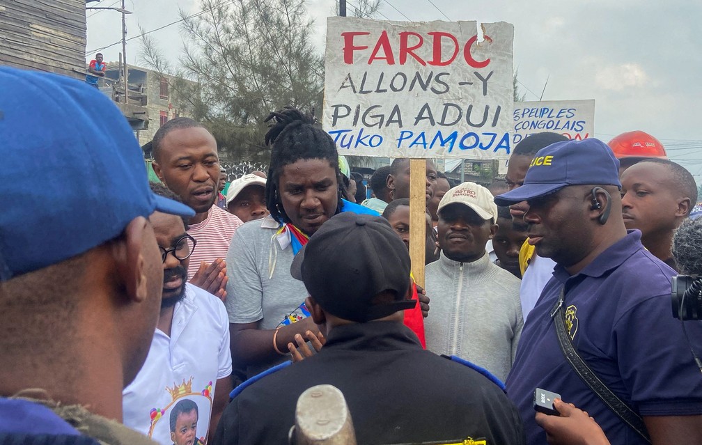 A polícia congolesa conversa com manifestantes pedindo às autoridades que imponham uma retirada acordada dos rebeldes M23 em Goma, na na República Democrática do Congo — Foto: Djaffar Sabiti/REUTERS
