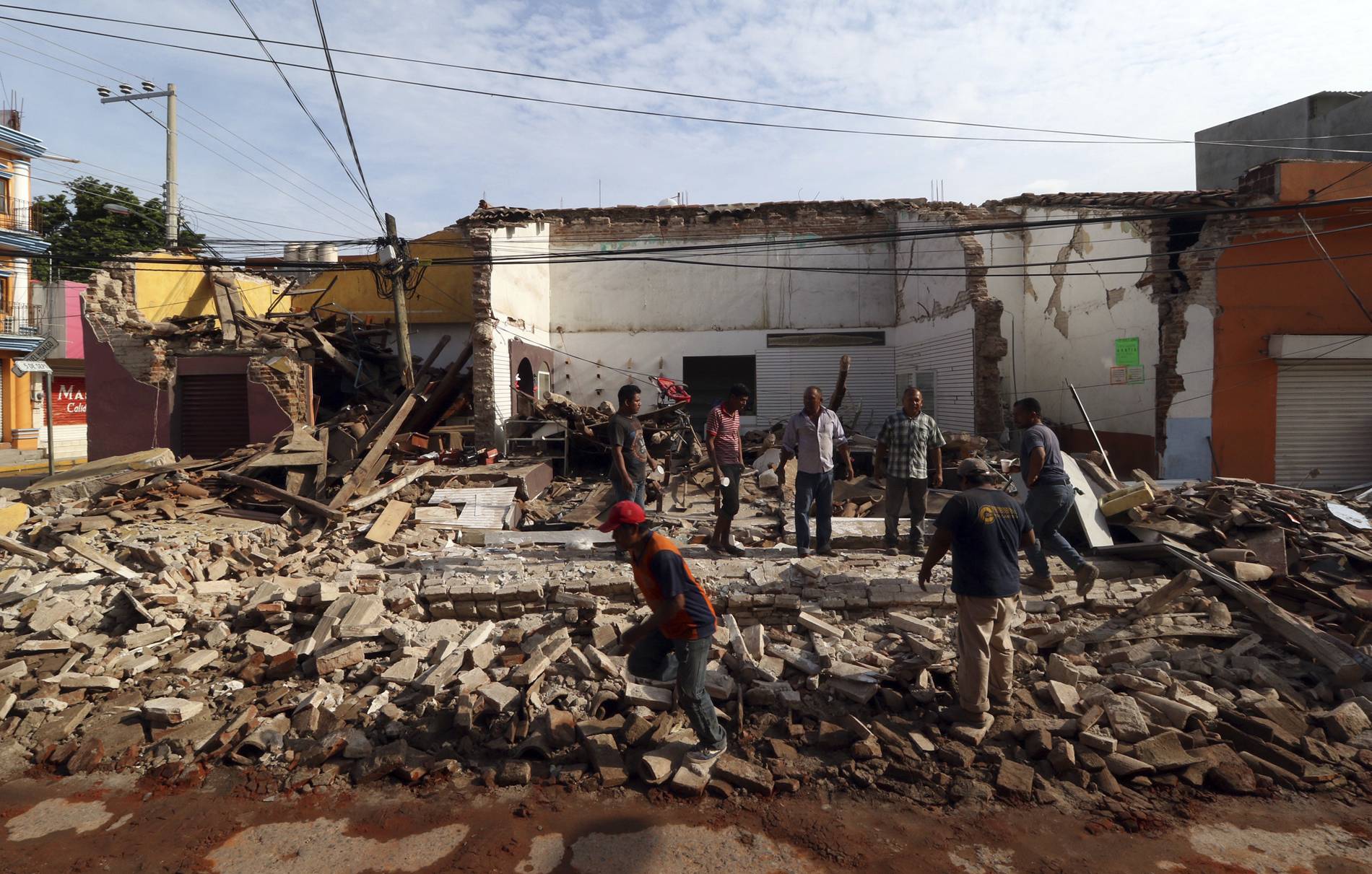Pessoas sao vistas em volta dos escombros de um edifício após terremoto, em Oaxaca, no México