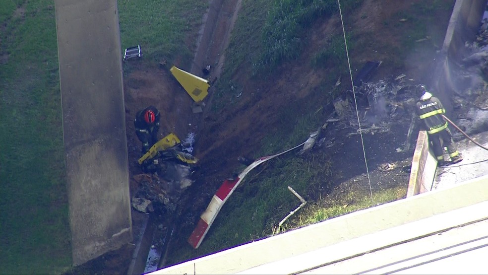 Bombeiros recolhem peças do helicóptero que caiu na Anhanguera — Foto: TV Globo/Reprodução