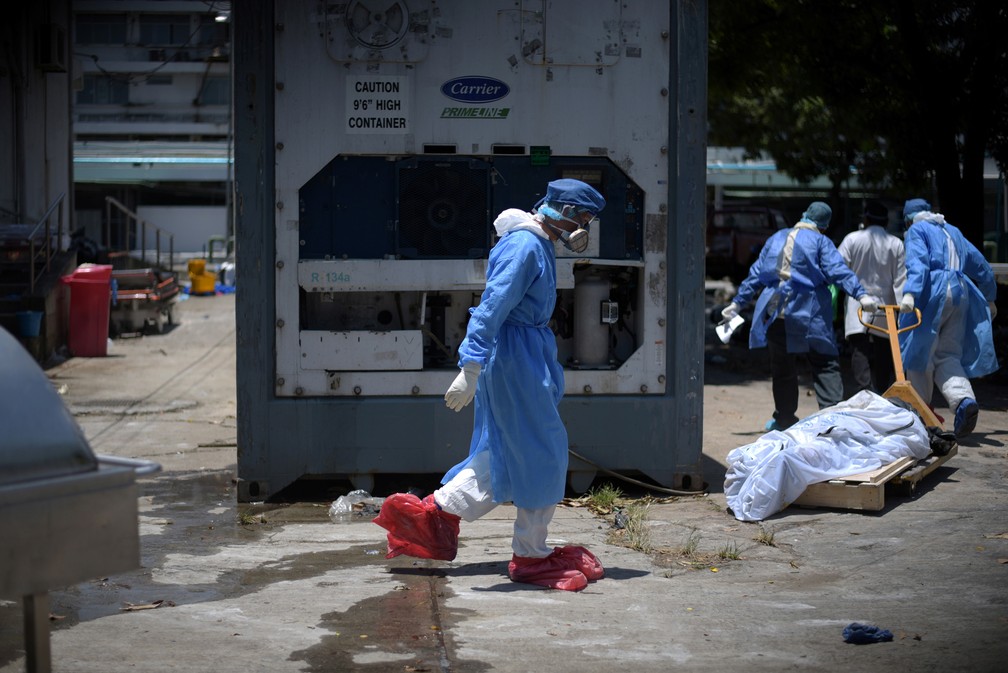 Profissionais de saúde com roupas e equipamentos de proteção carregam o corpo de uma pessoa morta por coronavírus no hospital Teodoro Maldonado Carbo em Guayaquil, no Equador, em imagem de 3 de abril de 2020 — Foto: Vicente Gaibor del Pino/Reuters