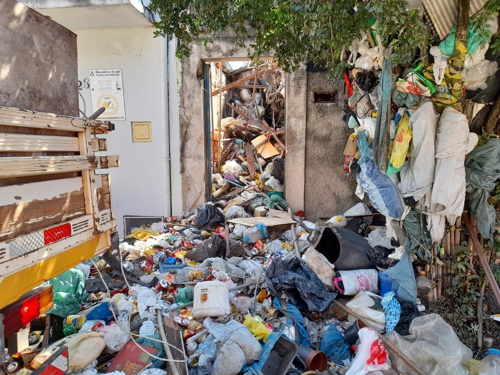 Entulhos e materiais recicláveis acumulados por décadas são retirados da casa por equipes da Defesa Civil, Bombeiros e populares em Piracicaba  — Foto: Edijan Del Santo/EPTV