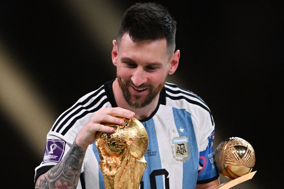 Messi com a taça do mundo e o prêmio de melhor da Copa
