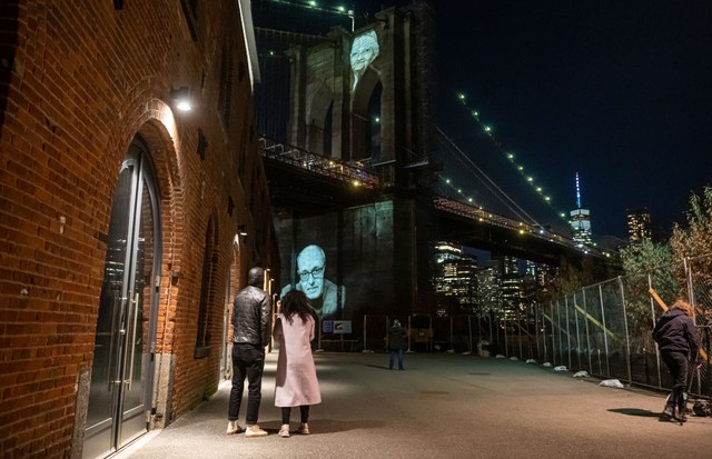 NEW YORK, NEW YORK - MARCH 14: Photos of people who died from COVID-19 are projected on the Brooklyn Bridge as part of the  “COVID-19 Day of Remembrance” memorial service on March 14, 2021 in the Brooklyn borough of New York City. The memorial service too (Foto: Getty Images)