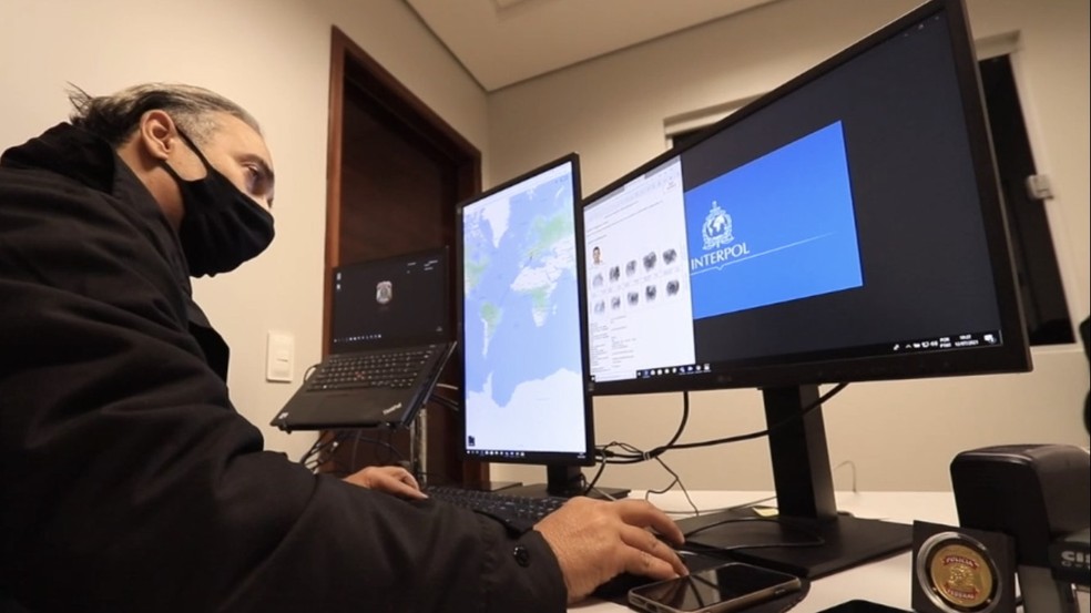 Policial federal inserindo informações no sistema da Interpol — Foto: Polícia Federal/Divulgação