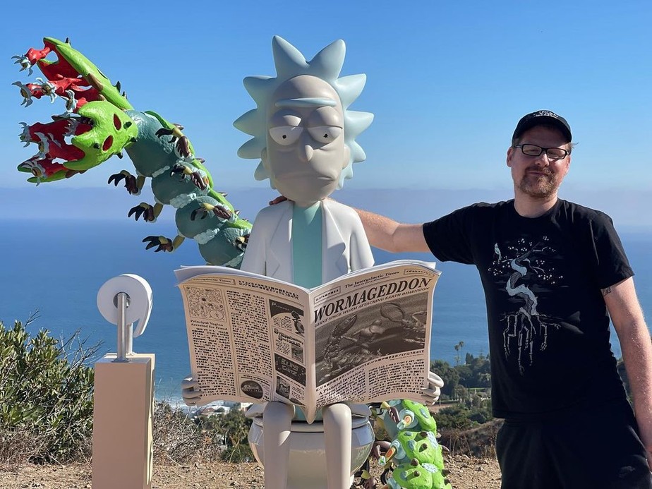 Justin Roiland posa ao lado de estátua de Rick, personagem da série 'Rick e Morty'