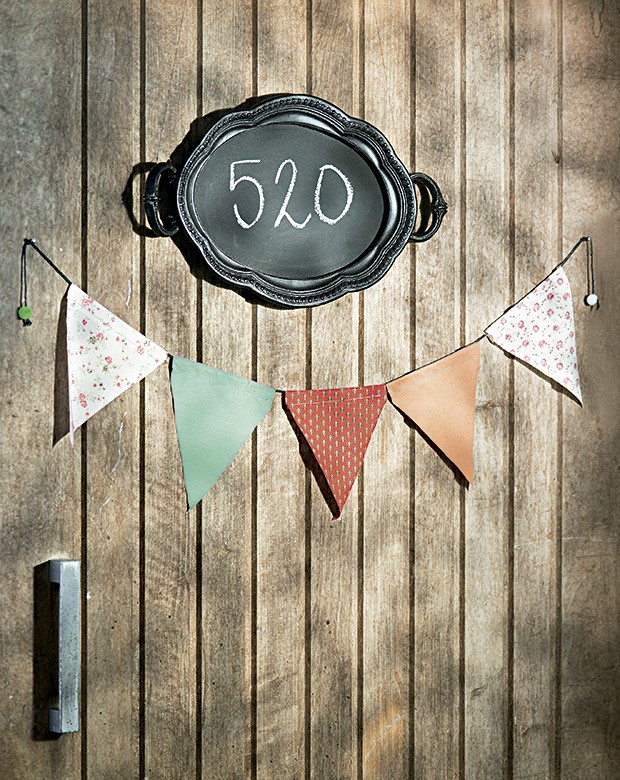 Boas-vindas diferentes: bandeirinhas Botões de Amora na porta e o número da casa escrito na bandeja-lousa Corporação de Ofícios (Foto: Cacá Bratke/Editora Globo)