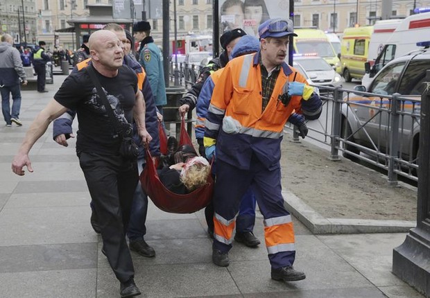 Bombeiros e equipe de resgate transportam mulher ferida em atentado no metrô de São Petersburgo, na Rússia (Foto: Anton Vaganov/EFE)
