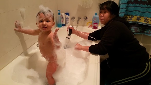 Max na banheira cheia de espuma com a mãe ao fundo (Foto: Reprodução)