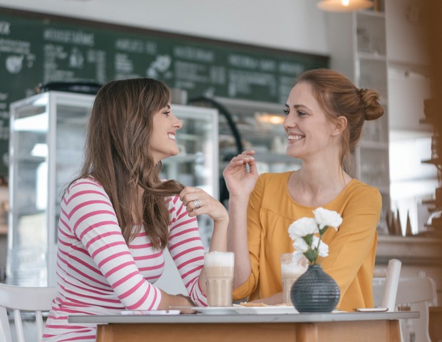 Two girlfriends meeting in a coffee shop, talking (Foto: Getty Images/Westend61)