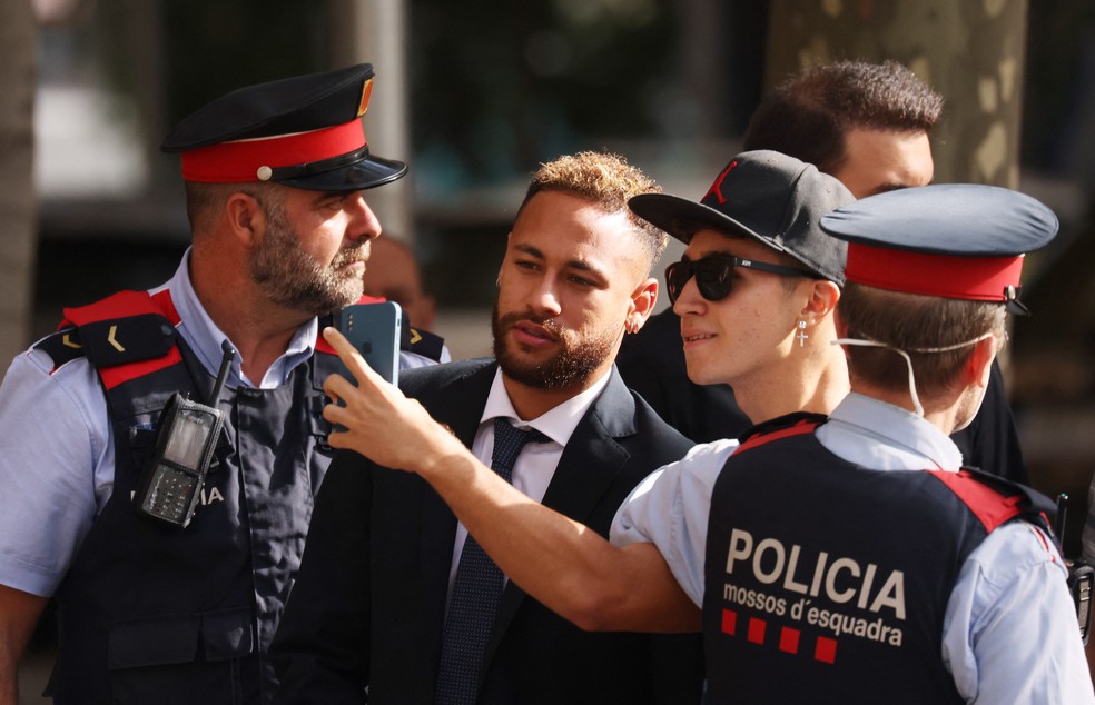 Jogador posa com fã antes da entrada no tribunal — Foto: Reuters