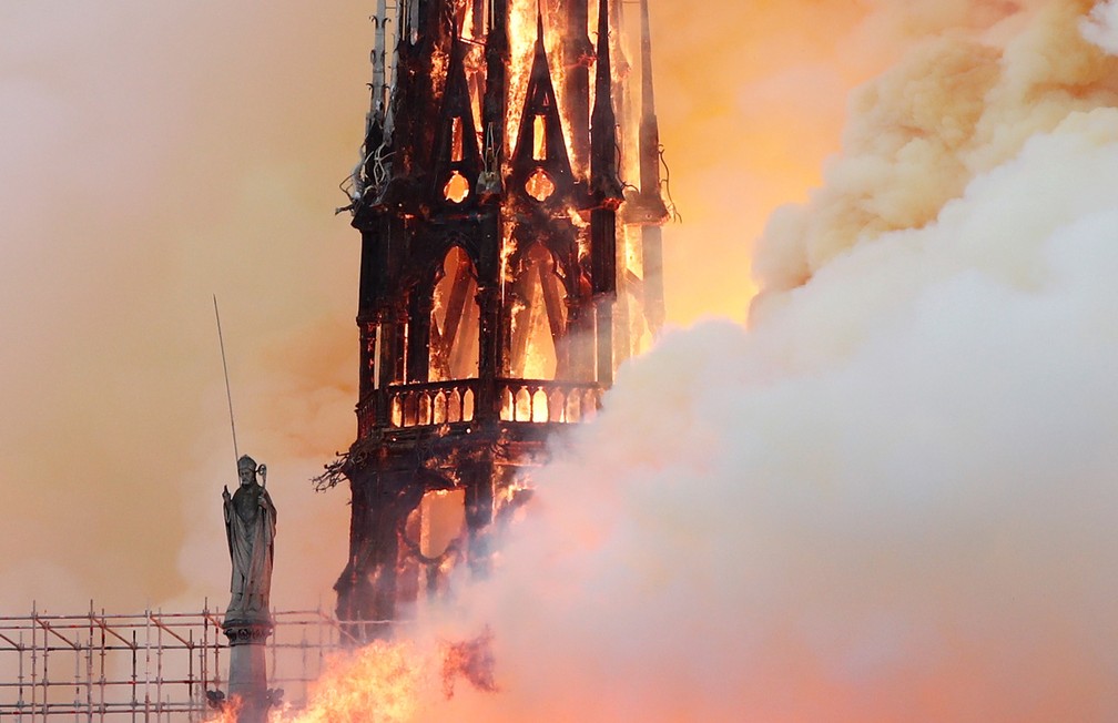 EstÃ¡tua da Catedral de Notre-Dame Ã© vista diante de torre em chamas durante incÃªndio em monumento histÃ³rico de Paris â Foto: Benoit Tessier/AFP