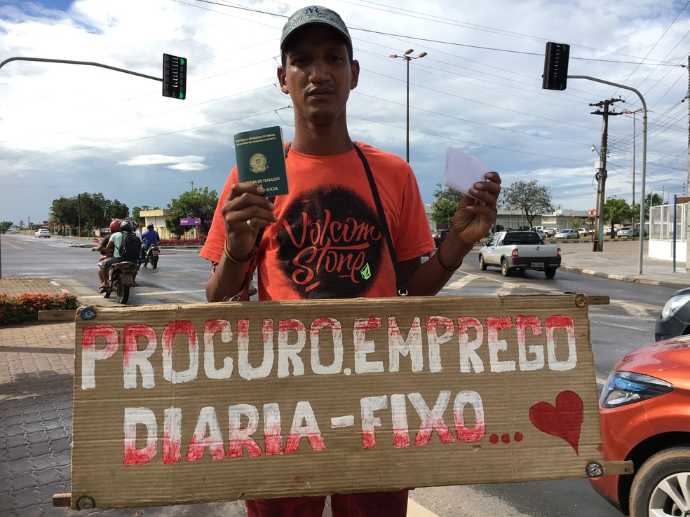 Venezuelano Carlos Eduardo segura placa em semáforo de Boa Vista; ele está há mais de um mês em busca de trabalho (Foto: Emily Costa/G1 RR)