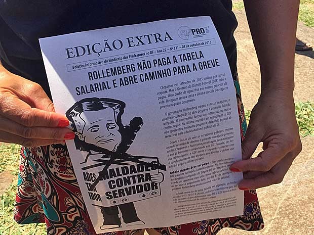 Manifestante mostra panfleto com crítica à suspensão de reajuste salarial ao funcionalismo do DF (Foto: Jéssica Nacimento/G1)