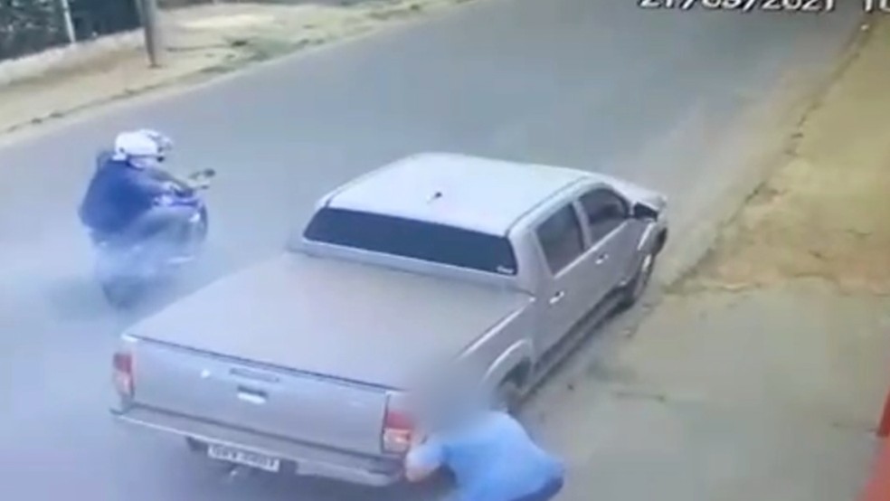Homem sofre tentativa de homicídio de dupla em moto e escapa após se esconder atrás de caminhonete — Foto: Câmeras de Segurança