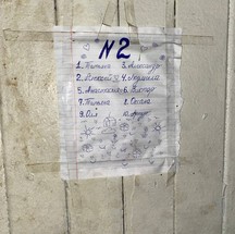 Lista com nomes de crianças que habitam o quarto número , em prédio ocupado por desalojados da guerra em Mariupol — Foto: Ekaterina Diachkova