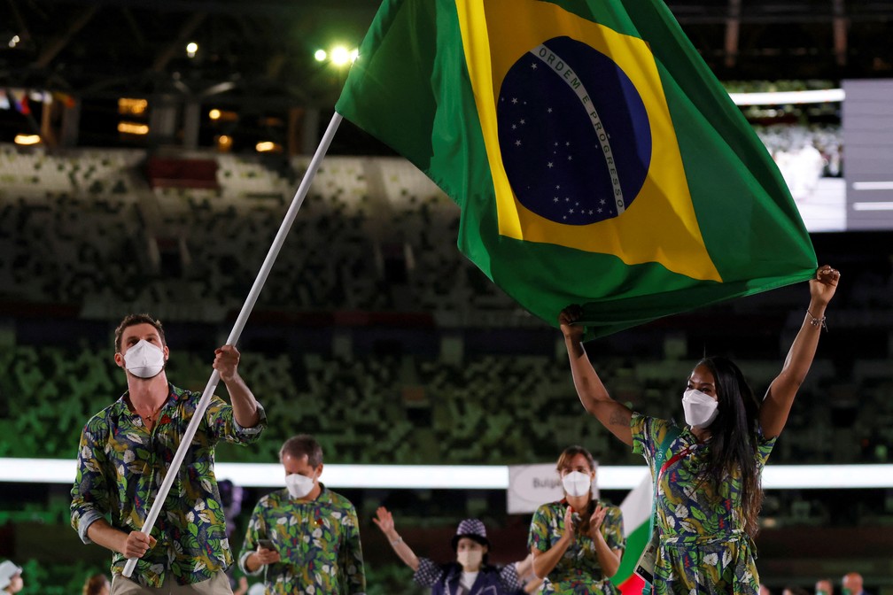 Ketleyn Quadros e Bruno Mossa carregam a bandeira do Brasil durante a cerimônia de abertura dos Jogos Olímpicos de Tóquio, no Japão — Foto: Odd Andersen/AFP